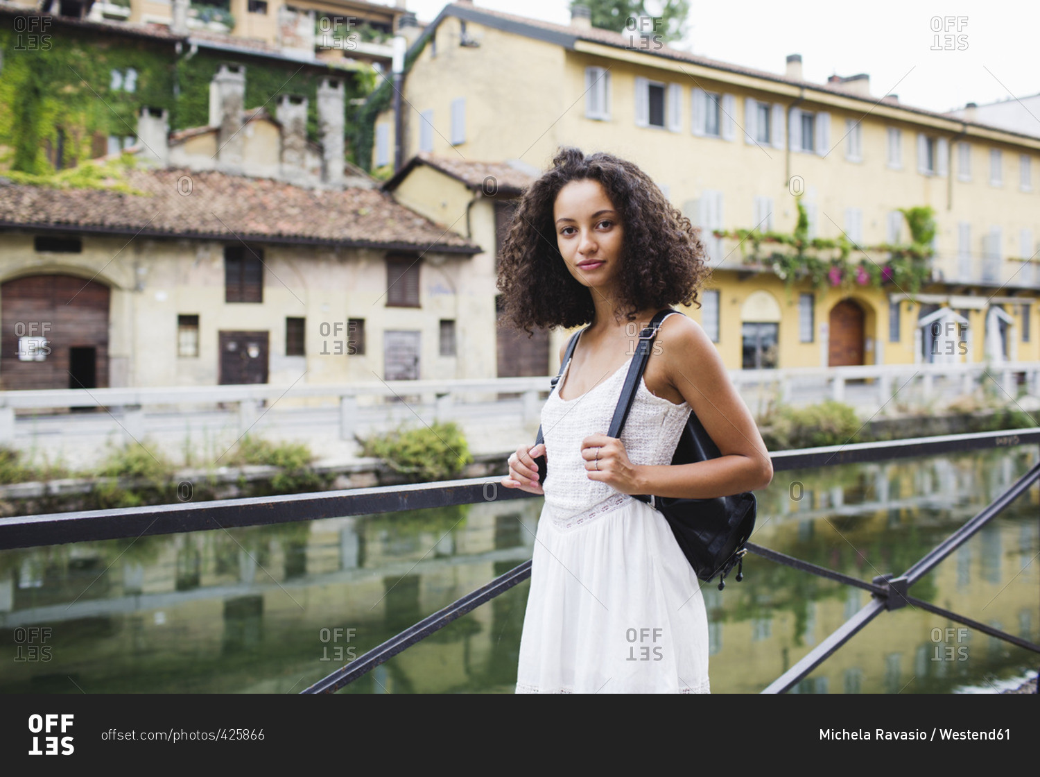 Italy- Milan- portrait of young woman with backpack wearing white summer dress