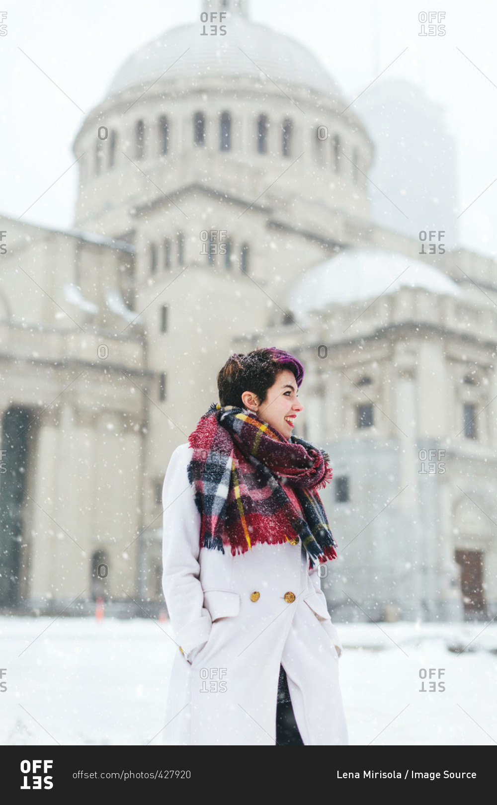 Young woman standing in front of the Christian Science Centre and Prudential building with snow, Boston, Massachusetts, USA
