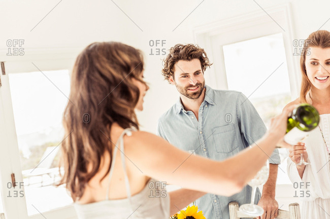 Woman pouring wine into friends wine glass