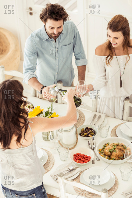 Woman pouring wine for friends