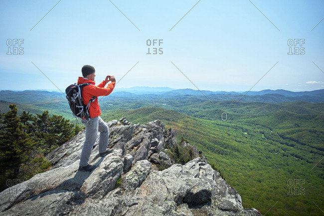 Male hiker taking smartphone photographs from ridge, Blue Ridge Mountains, North Carolina, USA