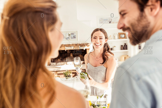 Woman in kitchen with friends smiling