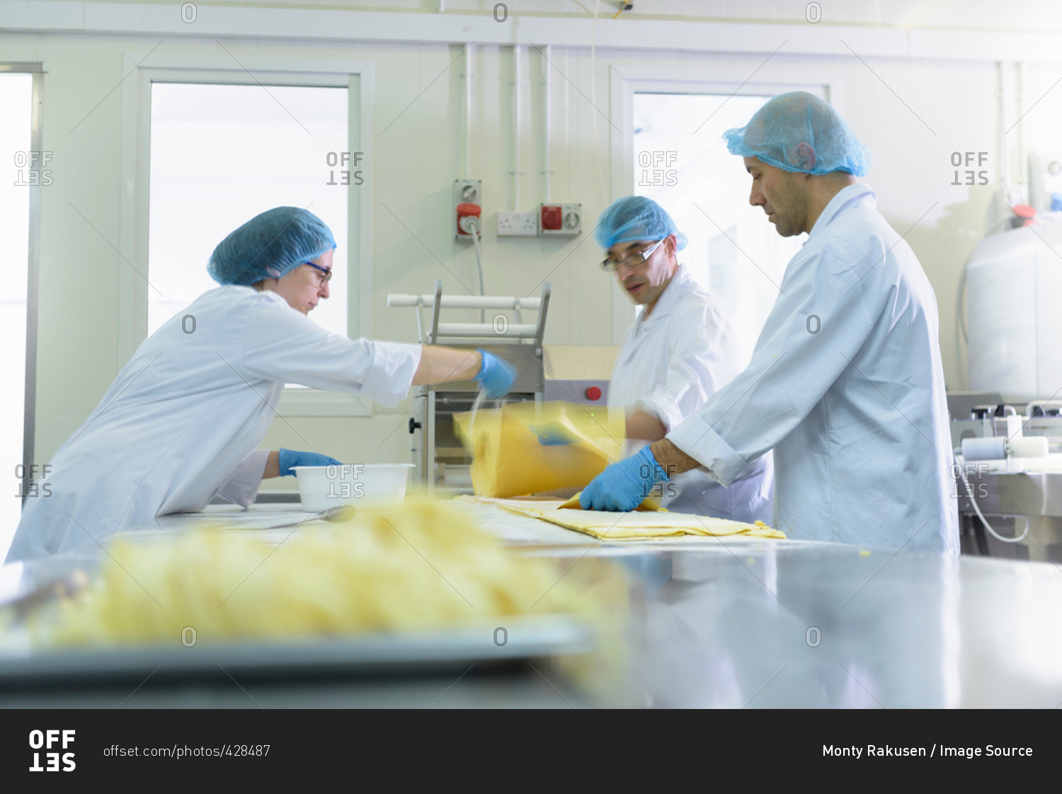 Workers making fresh pasta sheet in pasta factory