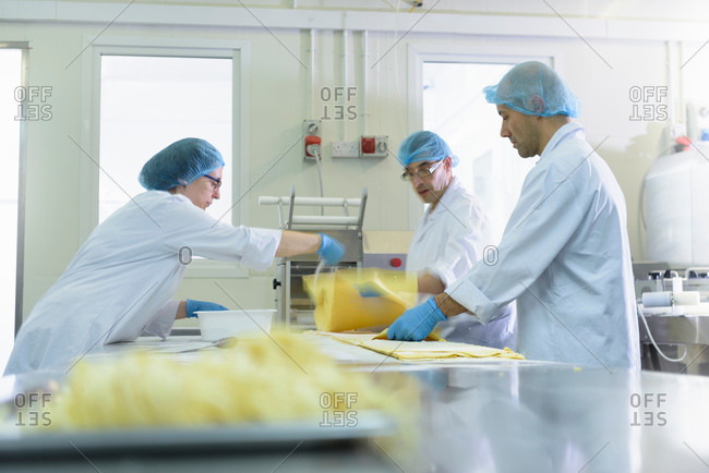 Workers making fresh pasta sheet in pasta factory