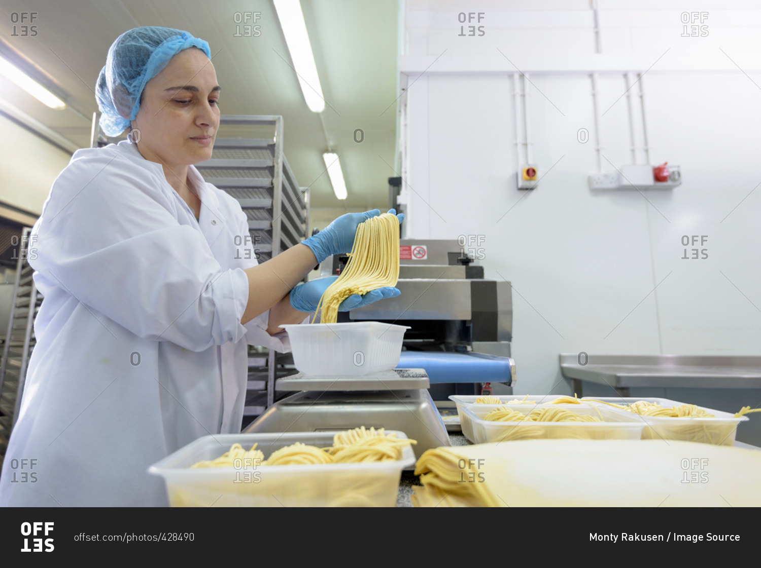Female worker making tagliatelle in pasta factory