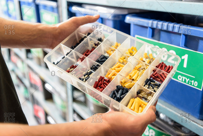Worker choosing parts in electrical parts factory, close up