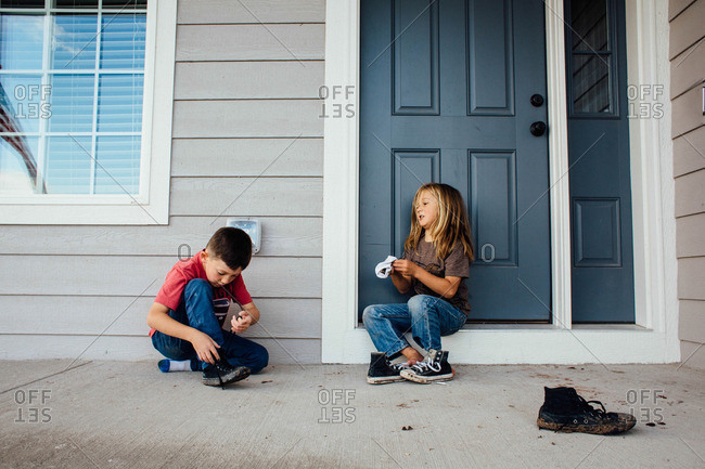 Two boys playing together on their porch
