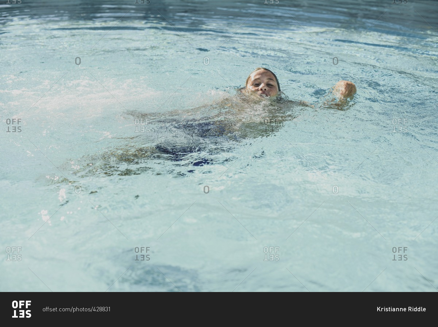 Boy splashing in a swimming pool