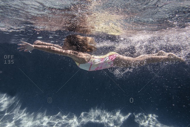 Side view of a girl swimming underwater in a swimming pool stock photo ...