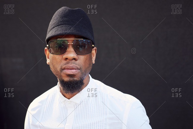 Serious African American man wearing sunglasses and hat