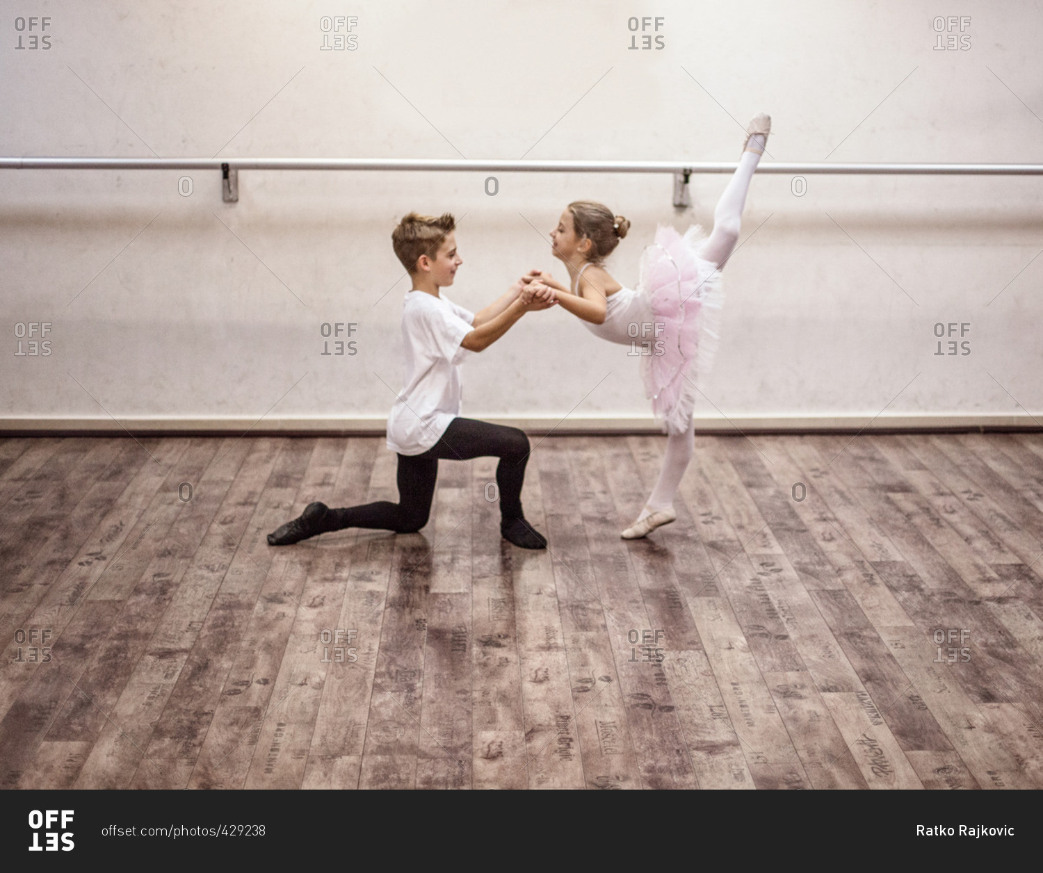 Boy and girl in ballet position stock photo - OFFSET