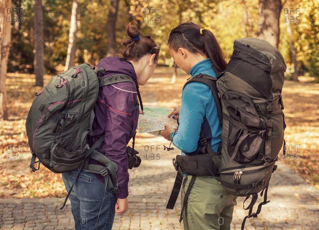 Women checking map in fall hike