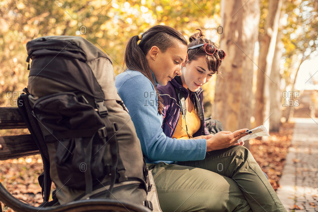 Backpackers on bench checking map