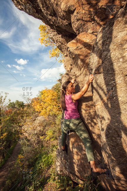 Woman rock climbing in the fall