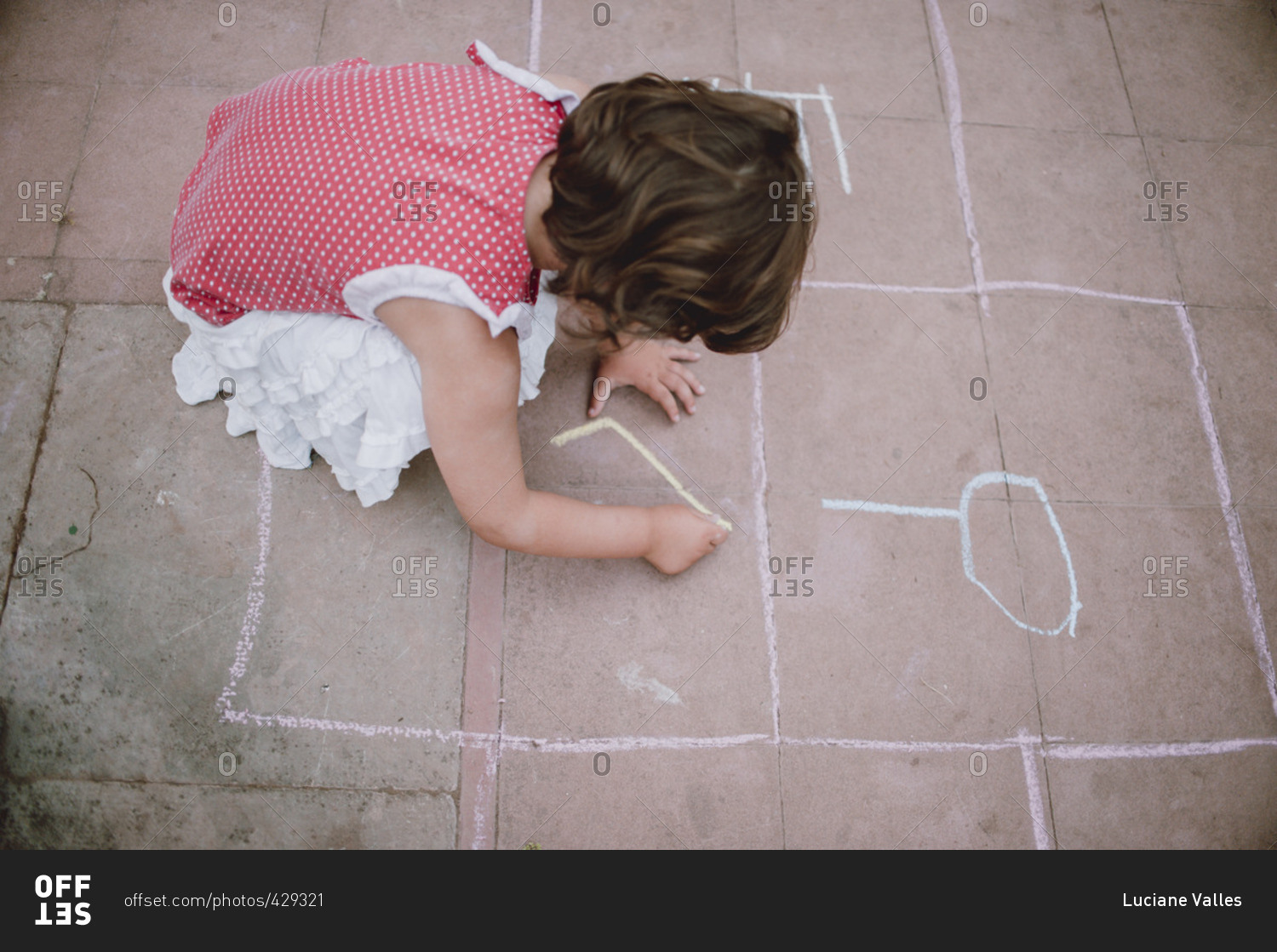 Girl drawing on the pavement with colorful chalk