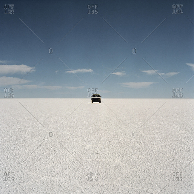 Vehicle parked on barren salt flat, Bolivia