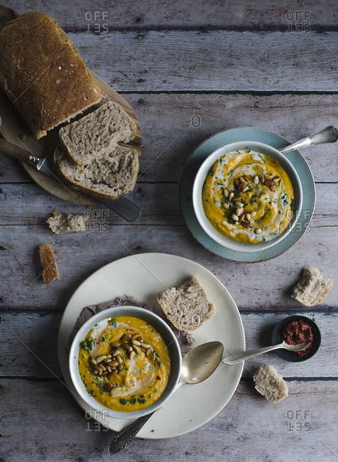 Bowls of squash soup with pine nuts and freshly baked bread