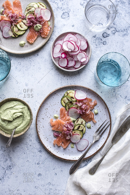 Plates of salad with salmon, grilled zucchini, and sliced radish