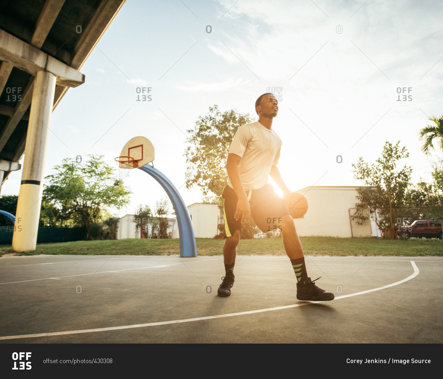 Men on basketball court holding basketball looking away