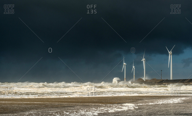 Four wind turbines amidst fierce storm waves and clouds at coast, Boulogne-Sur-Mer, Nord-Pas-de-Calais, France