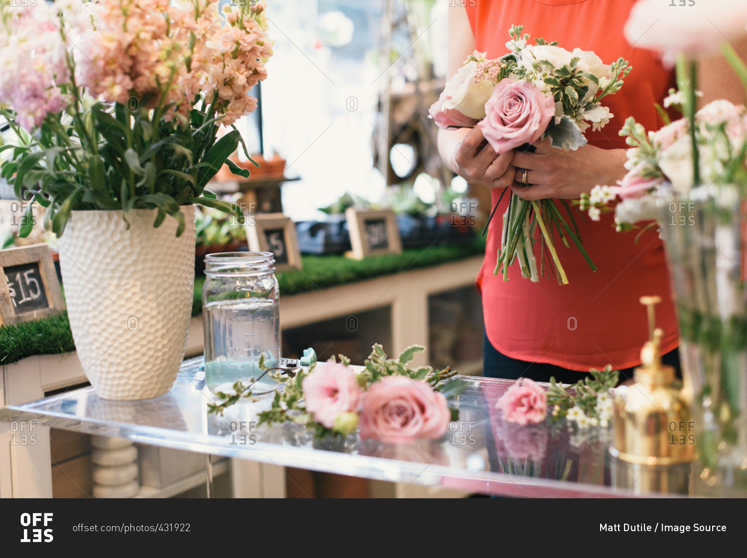 Florist arranging bouquet in flower shop, mid section