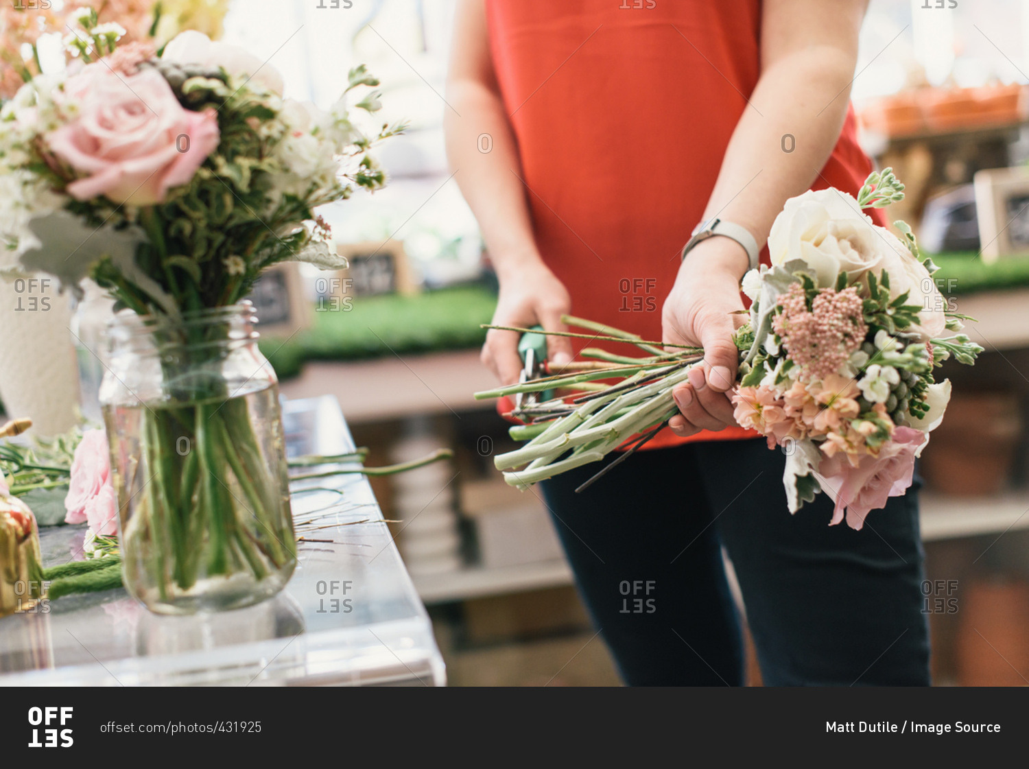 Florist arranging bouquet in flower shop, mid section