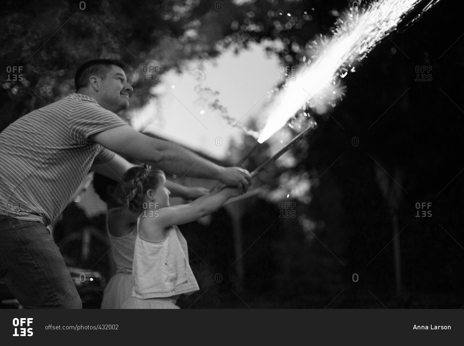 Father shooting fireworks with his children