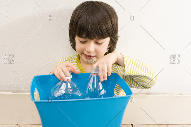 A boy holding a recycling bin