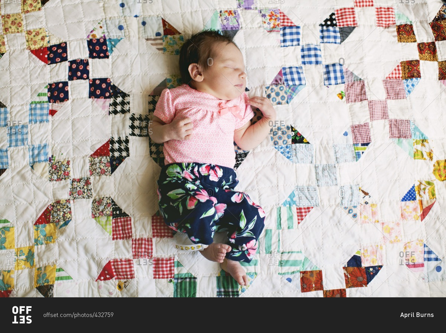 Sleeping baby lying on a colorful quilt