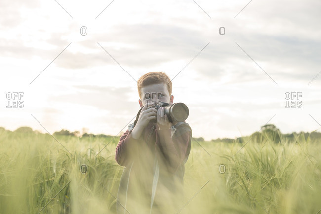 Portrait of a 10 year old boy taking photographs outdoors