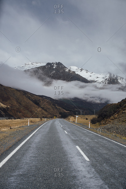 Empty highway and distant mountains in fog