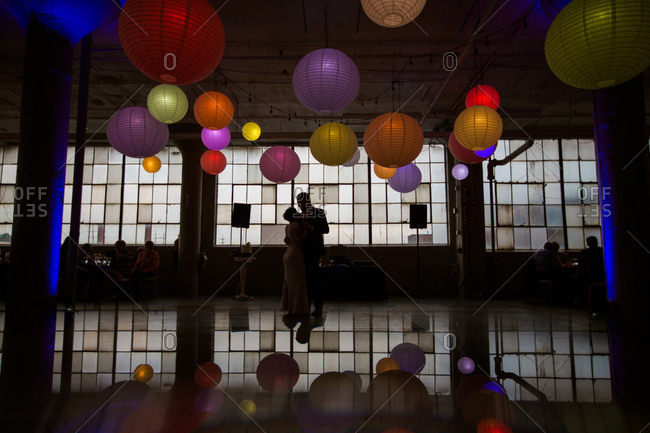 Bride And Groom Dance Under Colorful Paper Lanterns At Their