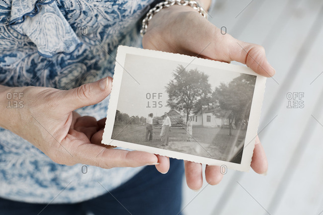 May 2, 2016: Woman holding old photograph of her farmhouse