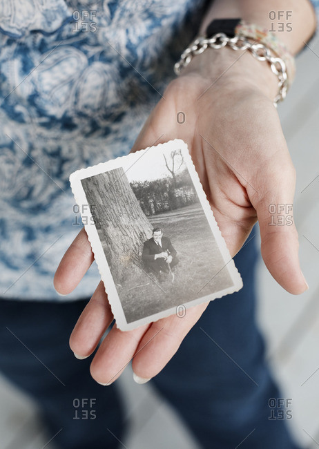 May 2, 2016: Woman holding old photograph of a man in her hands