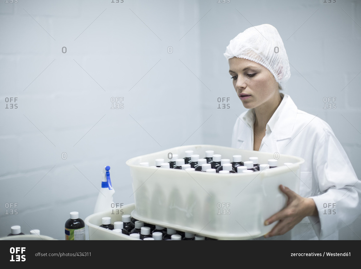 Woman carrying box of medical supplies in medical factory