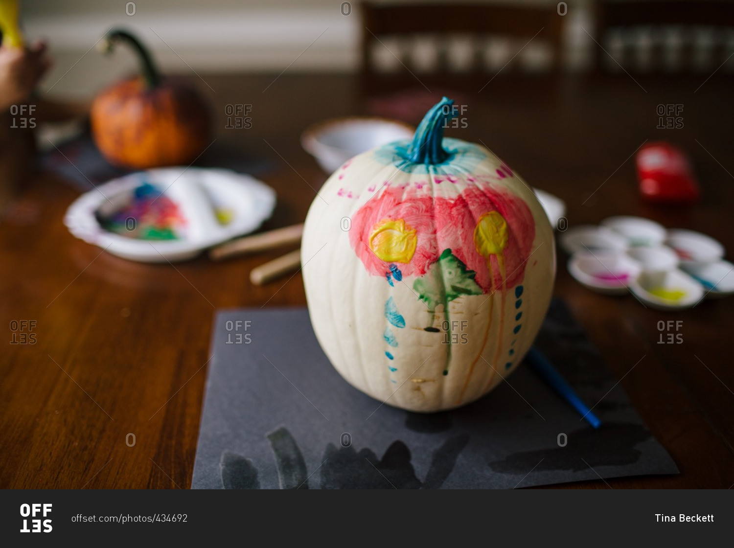 White pumpkin on a dining table with child\'s paint on it