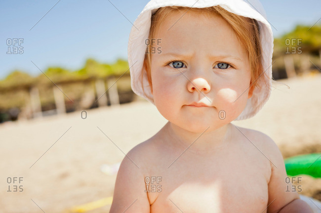 Toddler frowning on beach - Offset