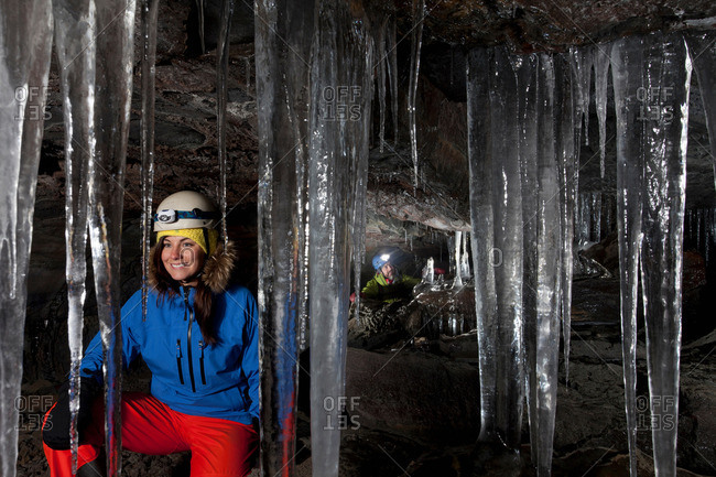 Hiker with icicles in glacial cave