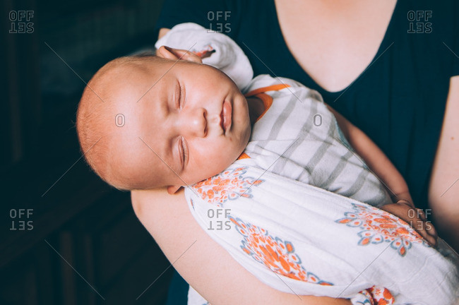 Close-up of sleeping infant sleeping in his mother's arms