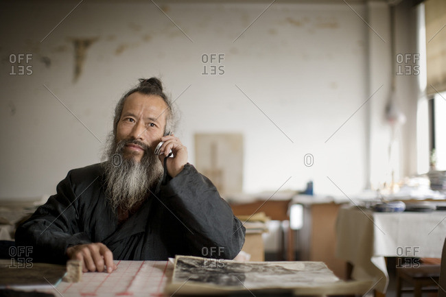 Artist sitting at his desk in his studio.