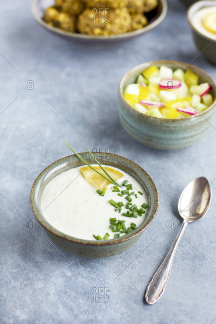 Bowls with charred lemon tzatziki, veggies, charred broccoli falafel and charred lemon tahini