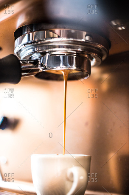 Professional espresso maker pouring espresso