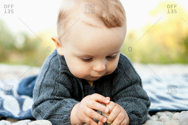 Baby playing with pebbles outdoors