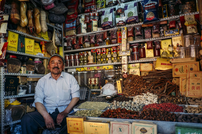 Kashgar, China - May 7, 2016: Uighur man sitting in his tea shop at a local market in old Kashgar