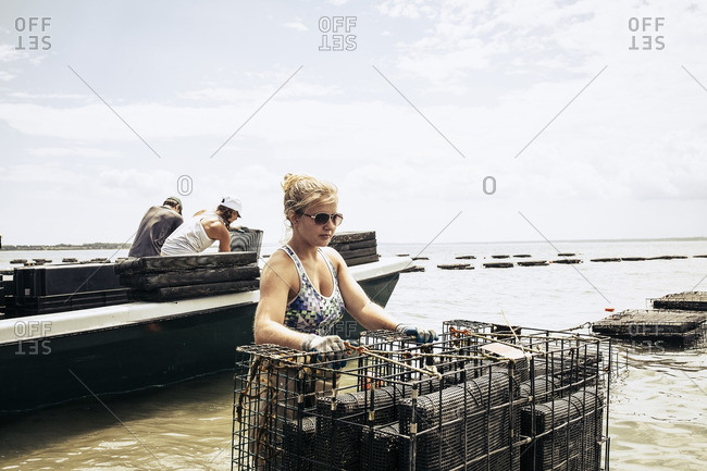Woman carrying oyster cages