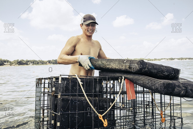 A man placing cages at oyster farm
