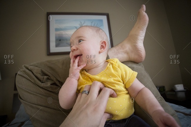 Baby on parent's lap being tickled