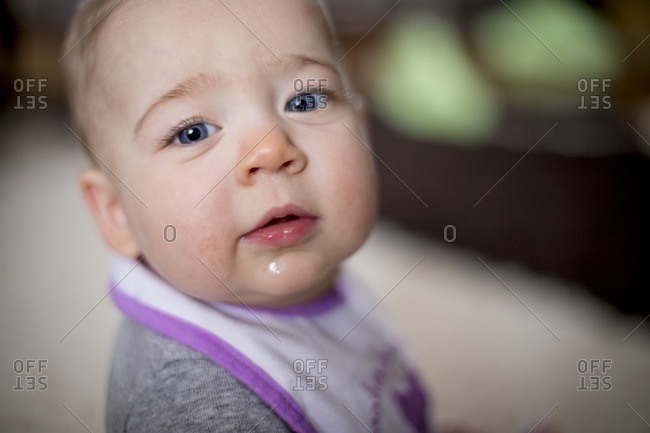 Baby wearing a bib with drool on face