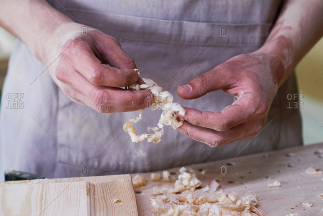 Man holding wood shavings in his workshop