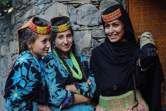 Chitral, Pakistan - May 20, 2016: Kalash teenagers smile outside house